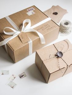 two brown boxes tied with white ribbon and twine