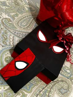 a red and black paper bag with a spiderman mask on it