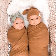 two babies wrapped in brown blankets laying next to each other