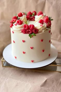 a white cake with raspberries and cream frosting