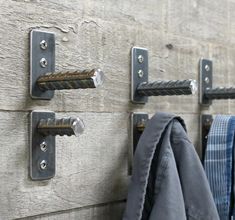 several coats hang on hooks in front of a wooden wall