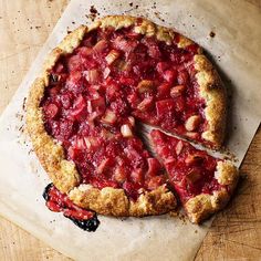 a pie that is sitting on top of a piece of parchment paper with a slice missing from it