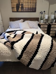 a bed with a black and white blanket on top of it