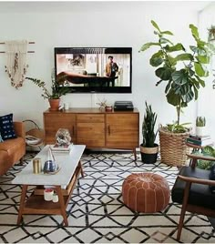 a living room filled with furniture and plants