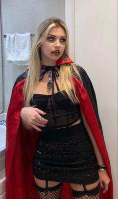 a woman dressed as a vampire posing for the camera with her hands on her hips