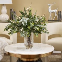 a vase filled with flowers sitting on top of a table next to two white chairs