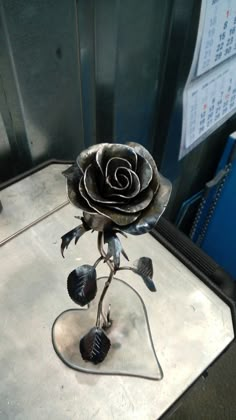 a metal rose sitting on top of a table