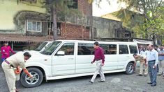 several people are standing around a white van