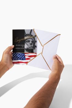 a person holding up a folded card with an american flag on it