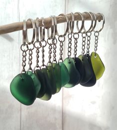 several green and black items are hanging from a metal hook on a white wall behind a wooden bar