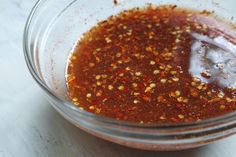 a glass bowl filled with sauce on top of a table