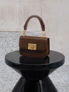 This product is made with at least 20% sustainable materials by weight. CHARLES & KEITH uses recycled, degradable, organic, and water-based materials in our eco-conscious collection. This timeless dark brown version of our metallic turn-lock bag is an investment piece that you can carry for all occasions. Featuring gold-toned hardware and a metallic turn-lock closure that opens up into a surprisingly spacious interior, this classy and compact piece can hold all your must-have items with ease. Carry yours by the top handle, or simply clip on the adjustable strap to turn it into a crossbody bag so you can go hands-free. Minimalist Bags, Charles And Keith, Minimalist Bag, Size Chart For Kids, Classic Bags, Charles Keith, 2023 Collection, Must Have Items, Winter 2023