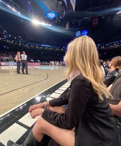 two women sitting on the bench at a basketball game