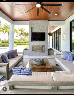 a living room filled with furniture and a flat screen tv mounted on the wall above a fire place