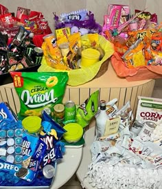 two baskets filled with candy and snacks sitting on top of a white plate next to each other