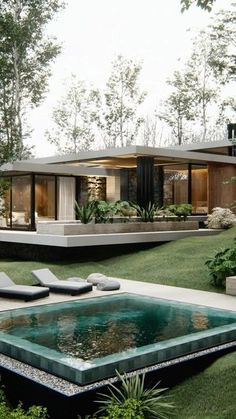 a modern house in the middle of a lush green yard with pool and lounge chairs