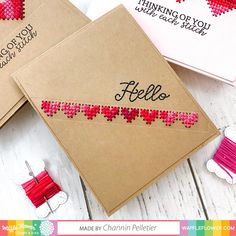 two greeting cards with the words hello written on them and some sewing pins next to it