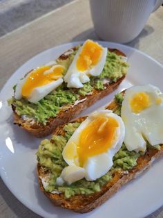 two pieces of toast topped with avocado and eggs