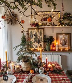 a dining room table decorated for christmas with candles and greenery