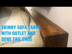 a wooden table sitting next to a white wall with text over it that reads skinnyy sofa table with outlet and dove tail ends