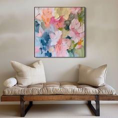 a couch with pillows on it in front of a wall mounted art piece that looks like an abstract painting