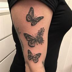 three butterflies tattoo on the right arm and left arm, with flowers in between them