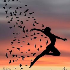 a person jumping in the air with birds flying around