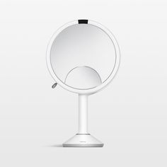 an image of a round mirror on top of a white stand with a black handle