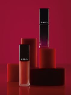 three different shades of lipstick on a red surface with the word chanel written in black