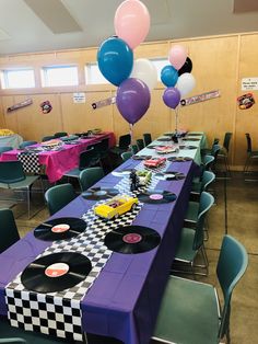 a table set up for a party with balloons and checkerboard table cloths