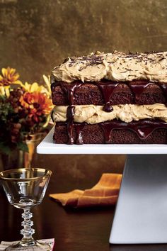 a cake with chocolate frosting and ice cream on top is sitting on a white platter