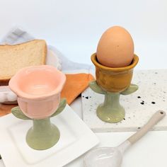 two egg cups and a spoon on a table