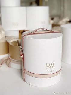 several white boxes with red trims and bows on them sitting on a table next to each other