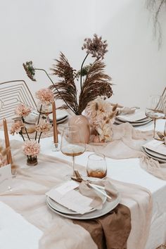 the table is set with flowers and place settings