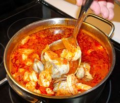 a person stirring food in a pot on the stove