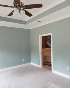 an empty room with a ceiling fan in the corner and carpet on the floor next to it