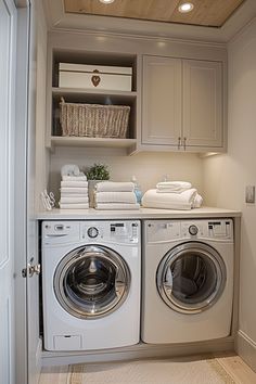 a washer and dryer in a small room with wooden ceiling above the door