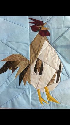 a close up of a quilt with a rooster on it's back and yellow legs