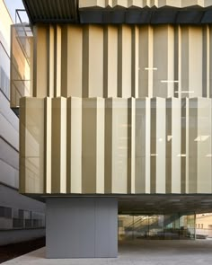 an empty parking lot in front of a building that has vertical striped panels on it