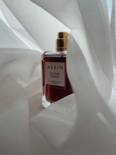 a bottle of perfume sitting on top of a white sheet