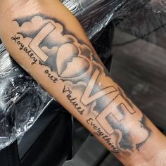 a man's arm with the word love tattooed on it