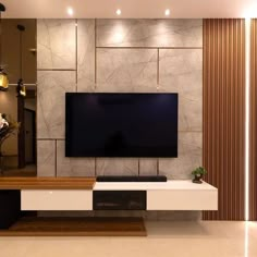 a living room with a large flat screen tv mounted on the side of it's wall