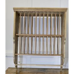 an old wooden bookcase with bars on the front and sides, against a white wall