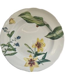 a white plate with yellow flowers and green leaves