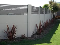 a white fence with some plants in front of it