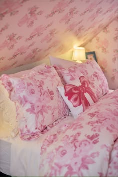 a bed with pink and white floral bedspread