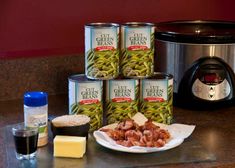 several cans of green beans are on the counter next to an instant pot and some other ingredients