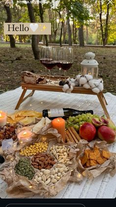 a table topped with lots of food next to a glass of wine and candlelight