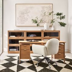 an office with a desk, chair and potted plant