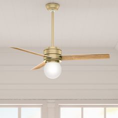 a ceiling fan with a light on top of it in a living room next to windows